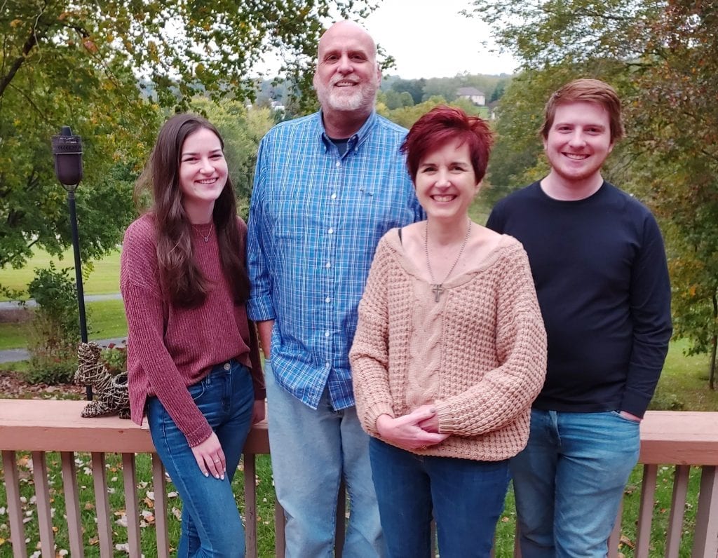 A pastor named Daniel Nicewonger lives with stage IV colon cancer smiles with his family, his wife, daughter and son.