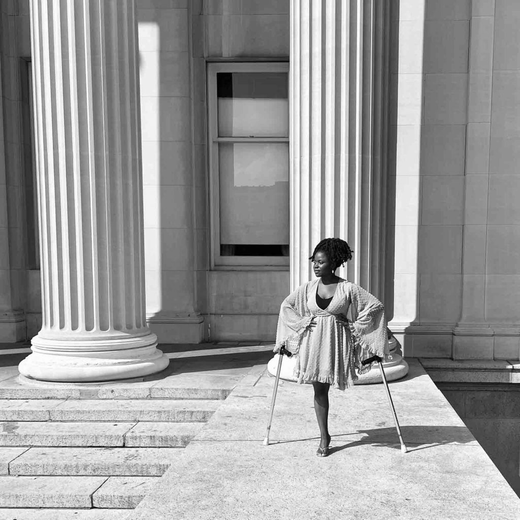 Wadzanayi Mayiseni, bone cancer survivor, stands in front of some tall white columns