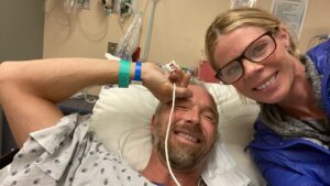 Dr. Jeff Myers smiles from a hospital bed.